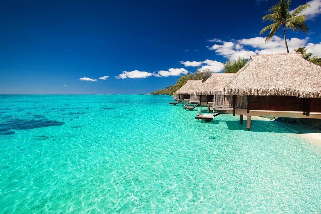 Villas on the green tropical beach with steps into water